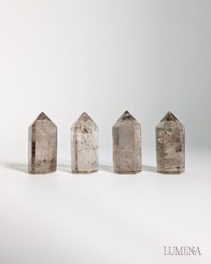 Image shows 4 mini smoky quartz points on a white background. Each point varies in deepness of colour.
