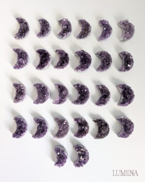 Image shows 26 Amethyst clusters which have been carved into a crescent moon shape.