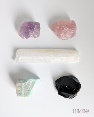 Image shows 5 raw crystals on a white background - amethyst, rose quartz, satin spar (selenite), amazonite and obsidian.